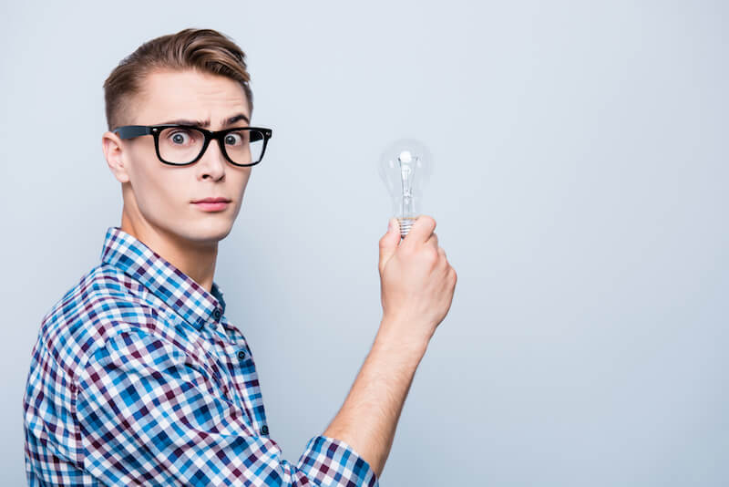 man with glasses holding a bulb