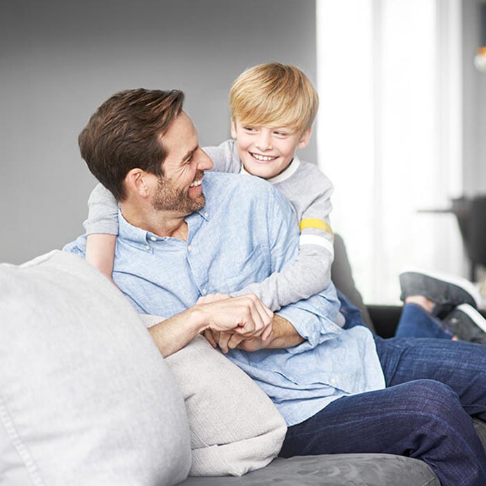 father and son playing on couch