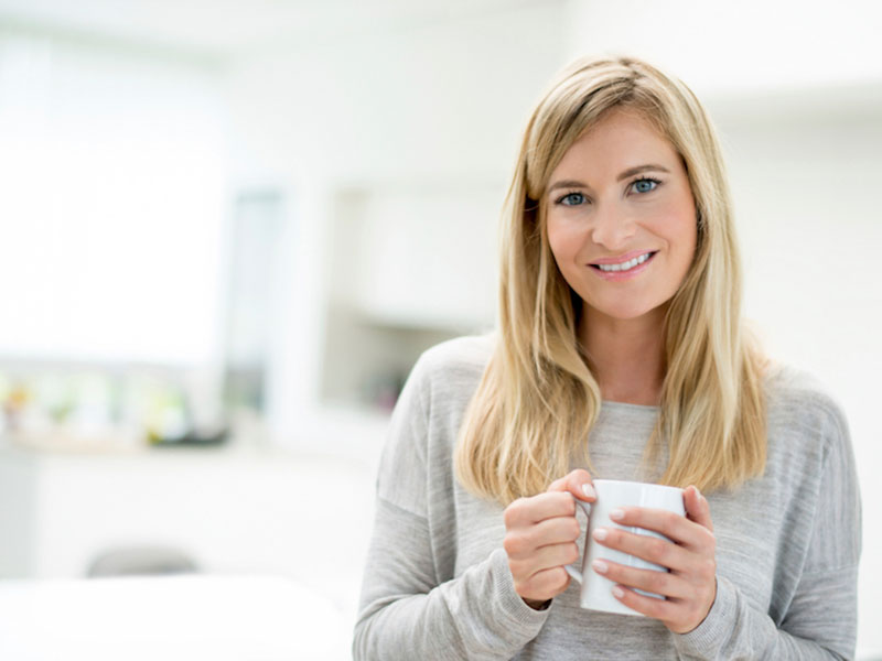 girl smiling with a cup on hand