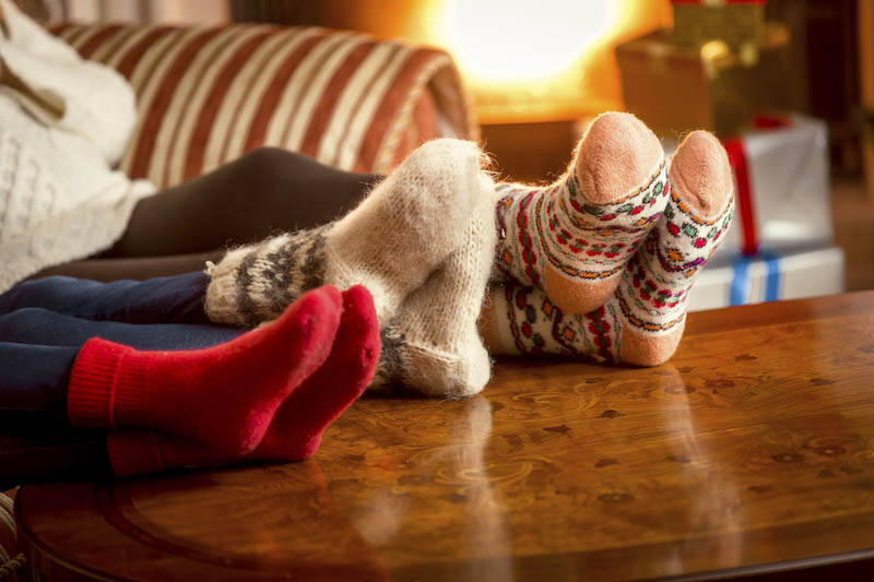 Closeup conceptual photo of family warming feet at fireplace